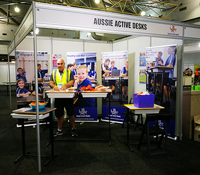 Photo of man at exhibition booth for Aussie Active Desks