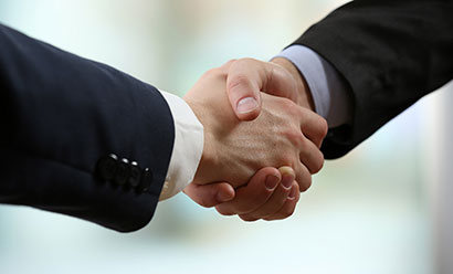 two male hands shaking wearing suits